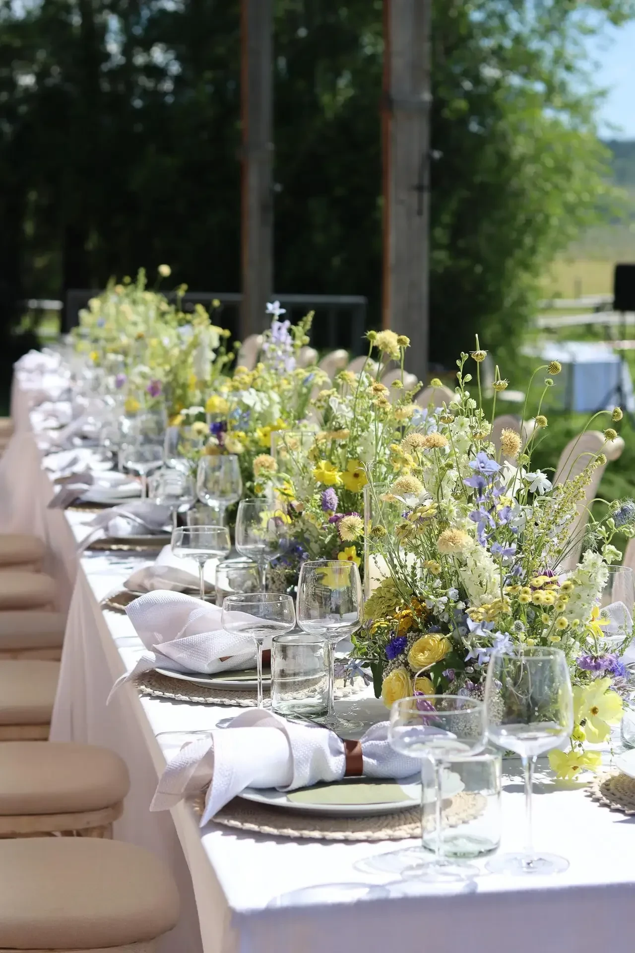Long reception table with airy garden-inspired centerpieces