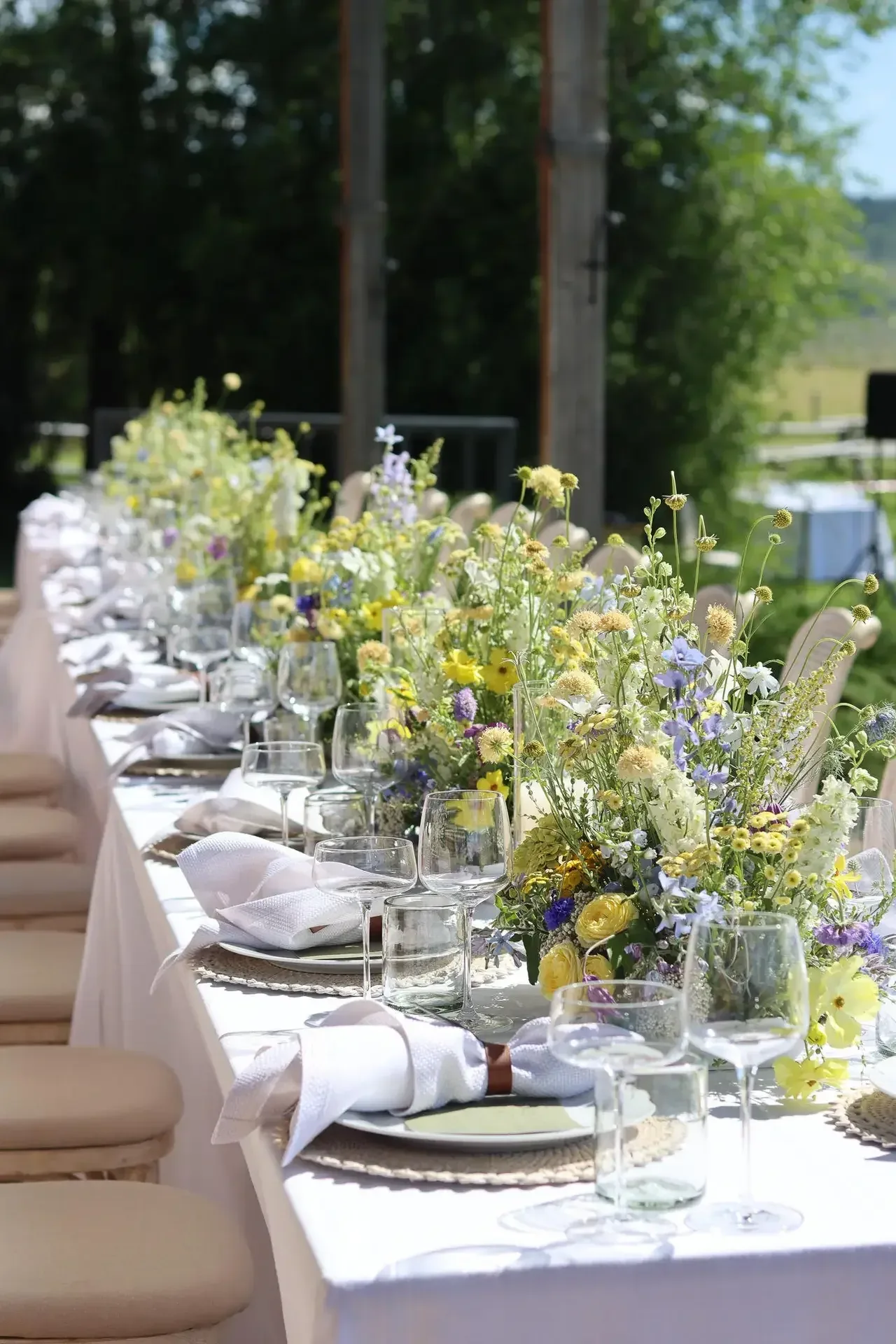 Long reception table with airy garden-inspired centerpieces