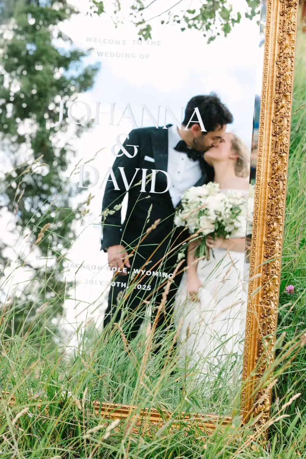 A couple reflected in a gilded wedding mirror installation