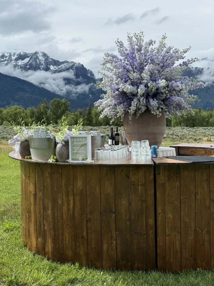 Round wood bar finished with purple florals and mountain peaks in the distance