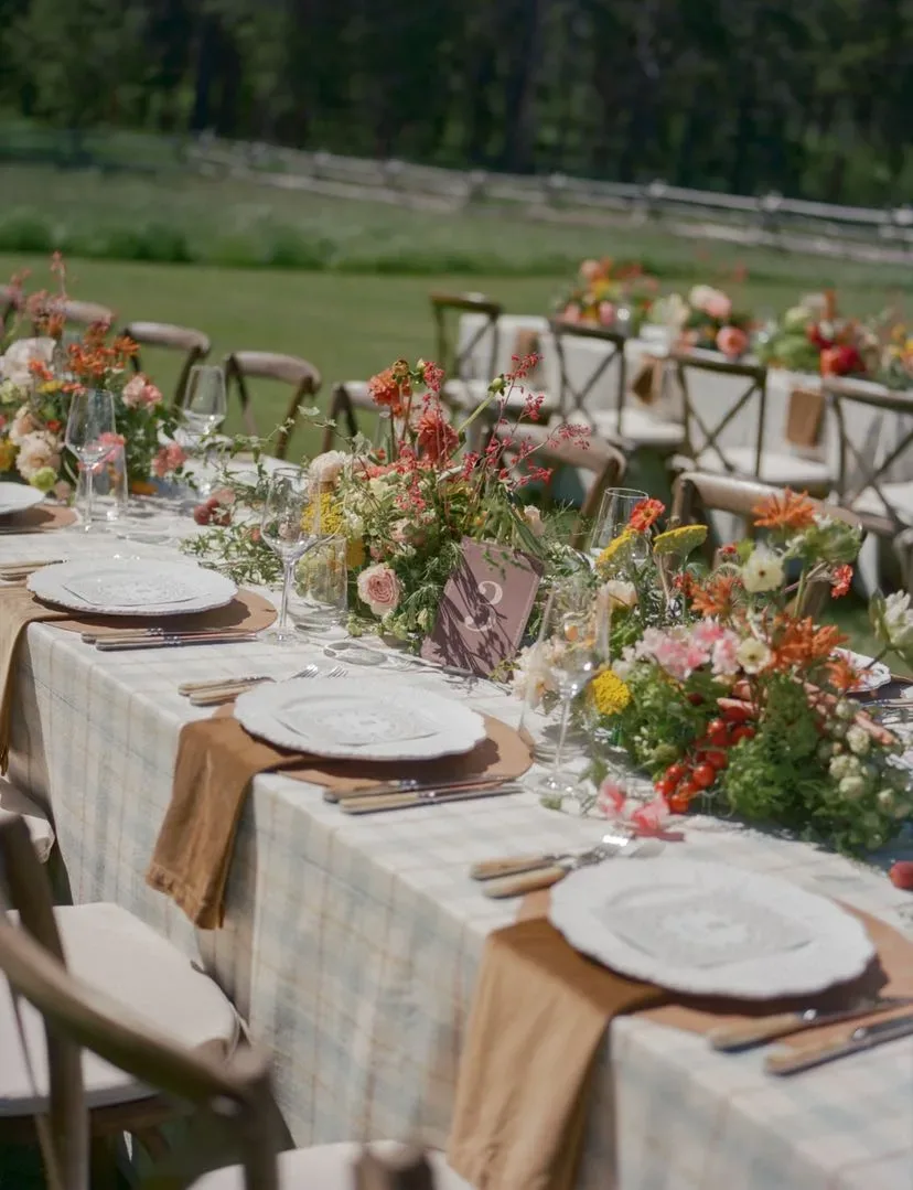 Outdoor ranch table with plaid linens and a meadow runner