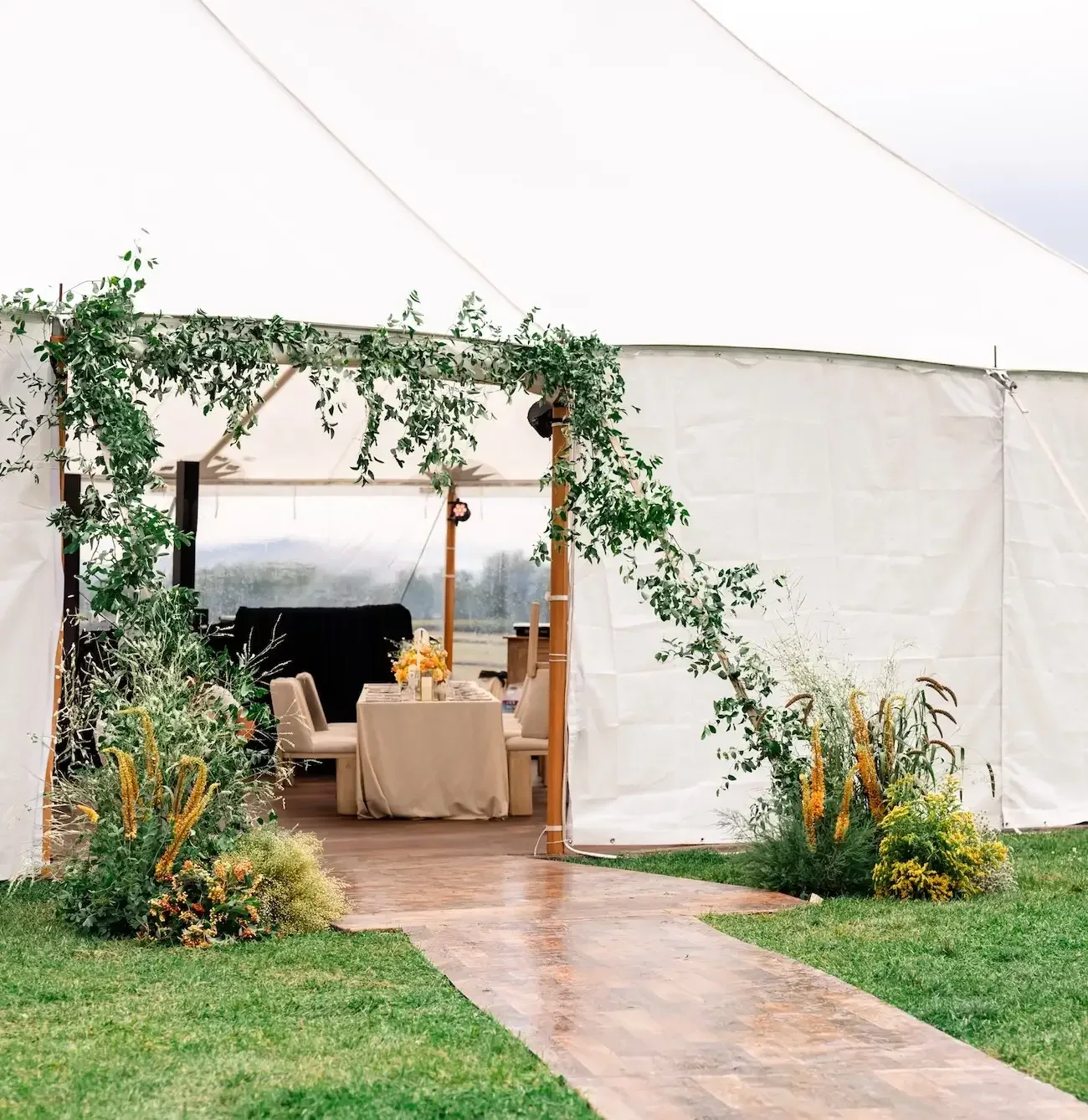 Tent entrance finished with large seasonal floral arrangements